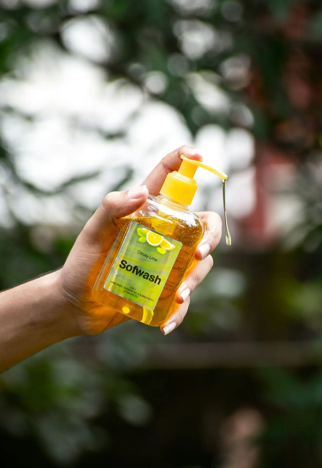 person holding yellow plastic bottle